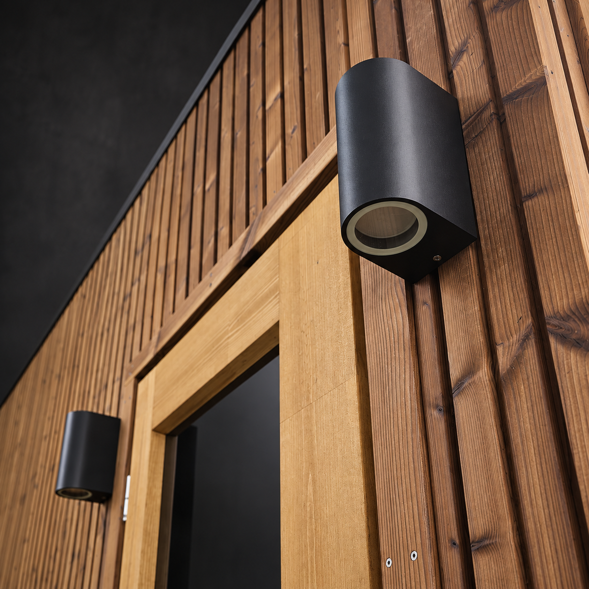 Exterior wall light on the timber cladding beside the door